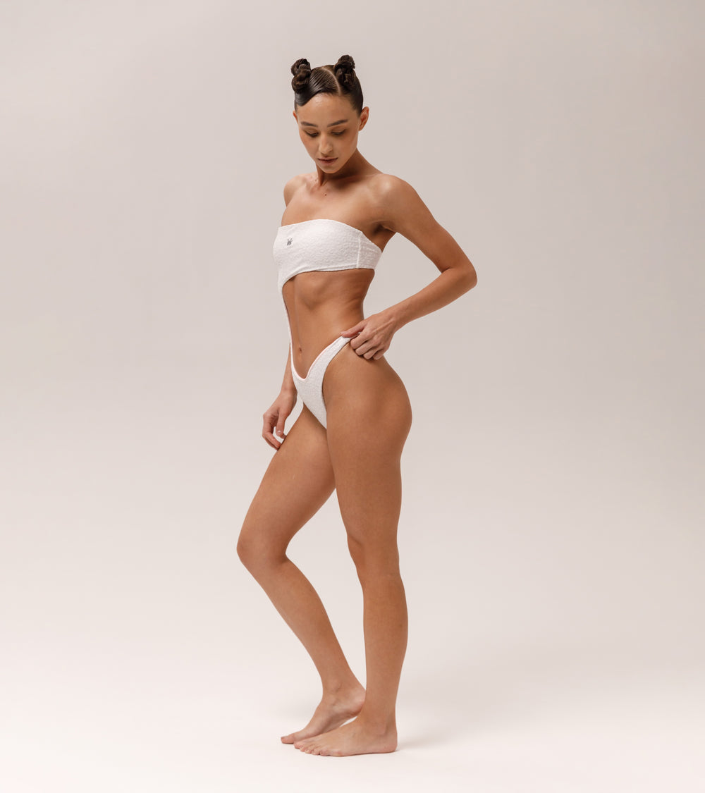 Model is wearing a Wealthywet 1971 one piece swimsuit in White Savannah