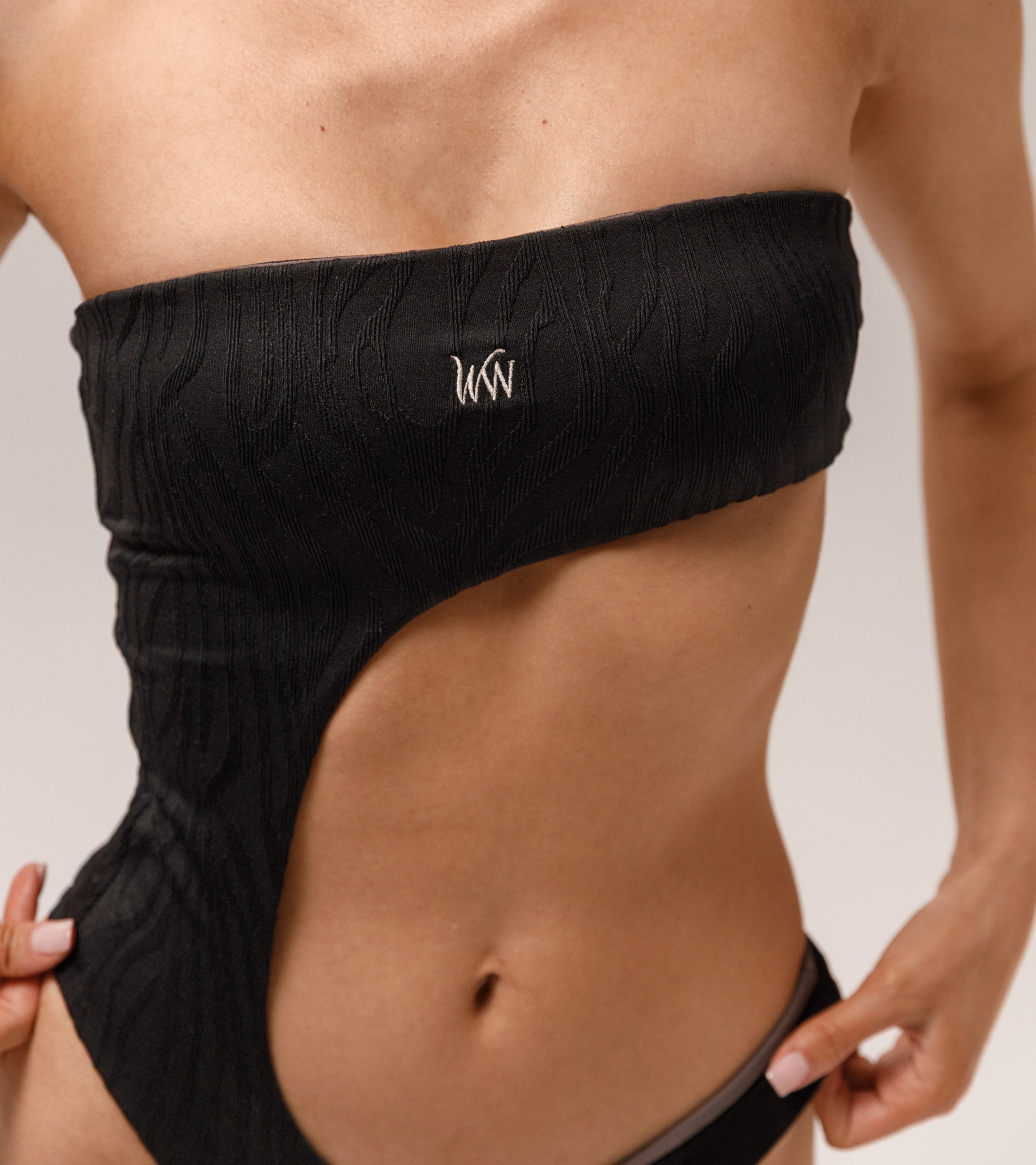 Close-up of the Wealthywet logo 1971 one piece swimsuit in Zebra Noir